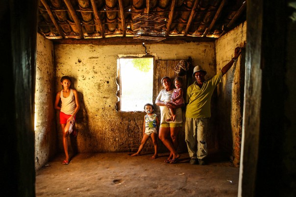 WJQUIXADA1 - CE - 18/08/2015 - SECA 100 ANOS/QUINZE - ESPECIAL PARA CIDADES OE - Cem anos depois da grande seca que assolou o sertão central do Ceará e inspirou o livro O Quinze, de Rachel de Queiroz, a região enfrenta outro grave período de falta de chuva pelo terceiro ano seguido. A reportagem refaz o trajeto da família fictícia criada pela escritora, formada por Chico Bento, Cordulna e cinco filhos, entre Quixadá e Fortaleza. Muita famílias ainda sofrem com a falta de água e não conseguiram produzir milhoe e feijão, os produtos da região. Na foto, Paulo Sérgio Alexandre Ferreira com a mulher, Zélia e os filhos Bianca, de 16 anos, Francisco Vitor, de 3, e Francisca Vitória, de 2. Cisterna instalada pelo governo do Estado está quase seca e família tem que pegar água em cacimba próxima ao barraco onde vive, na periferia de Quixadá. Foto: WILTON JUNIOR/ESTADÃO