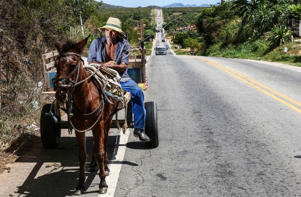 WJQUINZE208 - CE - 21/08/2015 - SECA 100 ANOS/QUINZE - ESPECIAL PARA CIDADES OE - Cem anos depois da grande seca que assolou o sertão central do Ceará e inspirou o livro O Quinze, de Rachel de Queiroz, a região enfrenta outro grave período de falta de chuva pelo terceiro ano seguido. A reportagem refaz o trajeto da família fictícia criada pela escritora, formada por Chico Bento, Cordulina e cinco filhos, entre Quixadá e Fortaleza. Muita famílias ainda sofrem com a falta de água e não conseguiram produzir milhoe e feijão, os produtos da região. Na foto, Em Acarape na CE 060 que liga Quixada a Fortaleza, Francisco Lopes da Silva, de 70 anos, leva ração em uma carroça. Este ano, conseguiu tirar apenas um saco (60 quilos) de feijão de seu pequeno roçado. Foto: WILTON JUNIOR/ESTADÃO